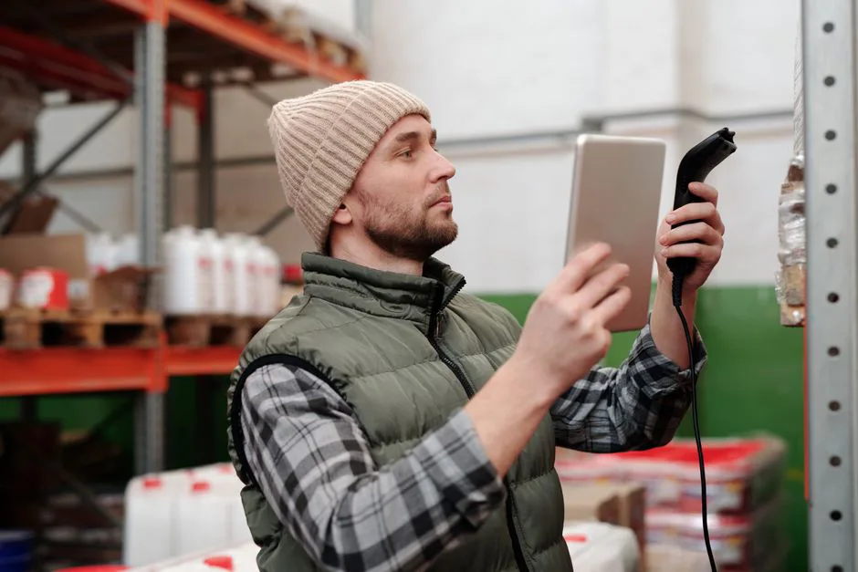 Almacén logístico con trabajadores organizando cajas y monitoreando pantallas de KPIs